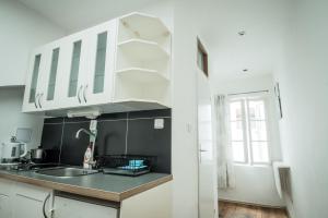 a kitchen with white cabinets and a sink at Charles Bridge Hostel & Apartments in Prague