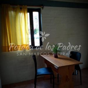 a dining room table with two chairs and a window at Posada de los Padres - EL KAKI in San Marcos Sierras