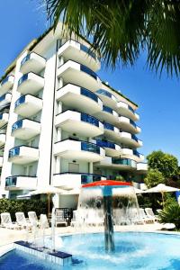 a hotel with a fountain in front of a building at Residence Oltremare in San Benedetto del Tronto