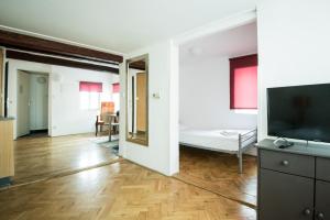 a living room filled with furniture and a tv at Charles Bridge Hostel & Apartments in Prague
