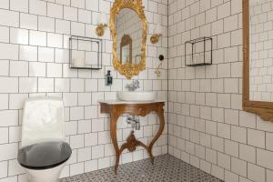 a bathroom with a sink and a toilet and a mirror at Hotell Hamngatan 27 in Falkenberg