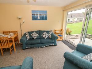 un soggiorno con un divano verde e un tavolo di Number 6 Oxwich Leisure Park a Swansea