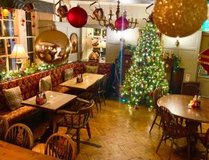 a christmas tree in a restaurant with tables and a christmas tree at Old Hall Hotel Hope in Hope