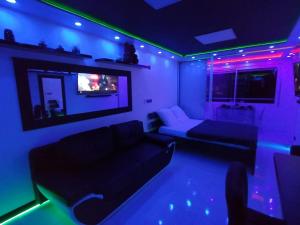a living room with purple and green lights at C12 Deluxe in Cap d'Agde