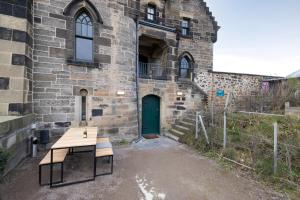 a wooden bench in front of a building with a green door at JOIVY Observatory House in Edinburgh