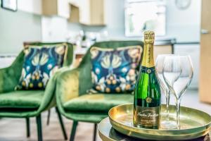 a bottle of champagne on a table with glasses at Pipkin Place Serviced Apartment Coventry in Coventry