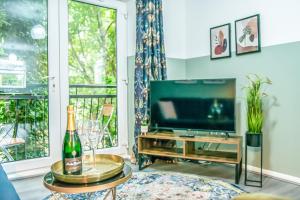 a living room with a television and a bottle of champagne at Pipkin Place Serviced Apartment Coventry in Coventry