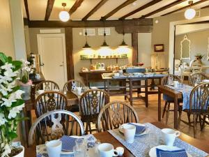 a dining room with tables and chairs and a kitchen at Hotell Hamngatan 27 in Falkenberg