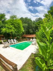 ein Swimmingpool mit Stühlen und ein Haus in der Unterkunft Posada Vieja Estancia in Santa Rosa de Calamuchita