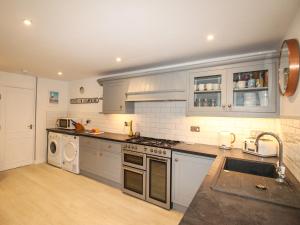 a kitchen with a sink and a stove top oven at Chesil Views in Portland