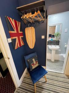 a bathroom with a blue wall and a blue chair at Delovely Hotel in Blackpool
