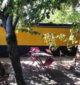 ein roter Stuhl neben einem Baum in der Unterkunft La Janvraie in Nantes