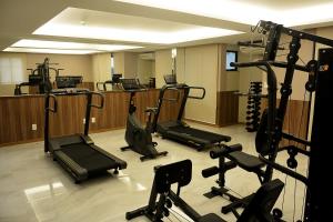 a gym with several treadmills and exercise bikes at Pituba Praiamar Hotel in Salvador