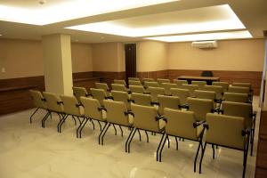 une salle de conférence avec des chaises et un podium dans l'établissement Pituba Praiamar Hotel, à Salvador