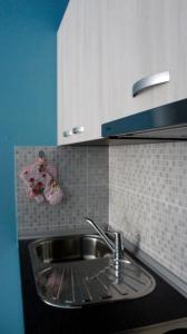 a kitchen with a sink and a tiled wall at Iris Studios in Umag +119 photos