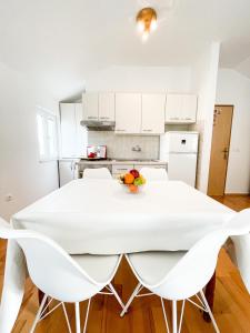 eine weiße Küche mit einem weißen Tisch und Stühlen in der Unterkunft Central Apartment Ira in Korčula