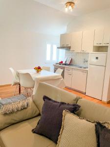 ein Wohnzimmer mit einem Sofa und einem Tisch sowie eine Küche in der Unterkunft Central Apartment Ira in Korčula