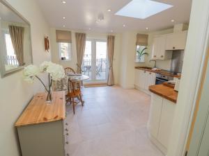a kitchen with a table with a vase of flowers on it at Bumble Cottage in Warwick