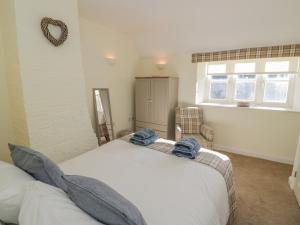 a bedroom with a bed with blue towels on it at Bumble Cottage in Warwick