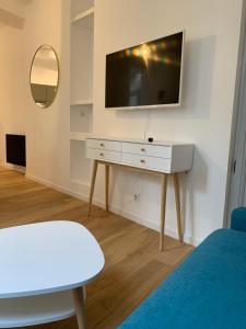 a living room with a tv and a white table at Les Tiercelines in Dole