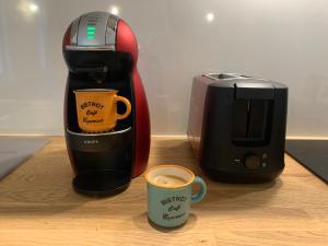 a coffee maker and a coffee mug next to a toaster at Les Tiercelines in Dole