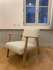 a chair sitting in a room with a window at Les Tiercelines in Dole