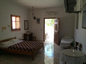 a bedroom with two beds and a table and a door at Mihalis Studios in Karpathos Town