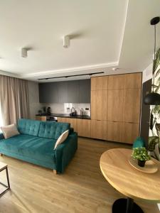 a living room with a blue couch and a table at Willa KWADRAT 12 in Sandomierz