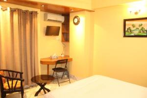 - une chambre avec un lit, une table et un bureau dans l'établissement Maple Crest Service Apartment, à Dhaka
