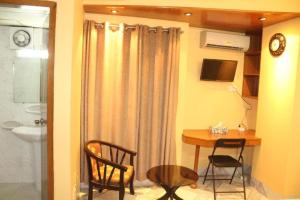 une chambre avec une table et des chaises et une salle de bains. dans l'établissement Maple Crest Service Apartment, à Dhaka