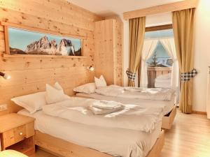 two beds in a room with a mountain view at Eurochalet in Campitello di Fassa