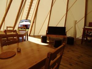 una habitación con mesa y sillas en una tienda de campaña en Nomad Planet, en Fiães do Rio