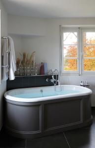 a large bath tub in a bathroom with a window at Le Domaine de Primard in Guainville