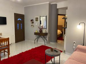 een woonkamer met een bank en een rood tapijt bij Lithotomia Mouzaki in Mouzákion