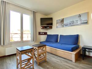 un salon avec un canapé bleu et une télévision dans l'établissement REF 016 Appartement T2 proche port Crouesty et parc du Fogeo, à Arzon