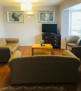 a living room with a couch and a tv at Atlantic Hotel in Lahinch