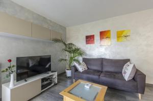 a living room with a couch and a tv at Superbe Appt Port Marianne, Parking Privé, 4 personnes in Montpellier