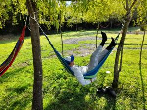 un hombre tendido en una hamaca en un parque en Lodge Guarida del Trauco, en Puqueldón