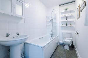 uma casa de banho branca com um lavatório e um WC em Goldsmith Serviced Apartment Coventry em Coventry