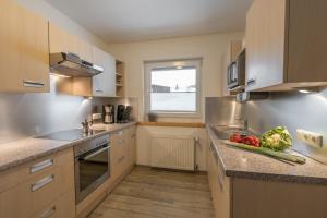 a kitchen with a sink and a counter with vegetables on it at Ferienwohnungen Alpentraum - Alpentraum in Obermaiselstein