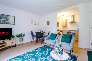 a living room with two chairs and a tv and a table at Goldsmith Serviced Apartment Coventry in Coventry