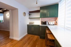 a kitchen with green cabinets and a counter top at Host & Stay - Iris Cottage in Pickering