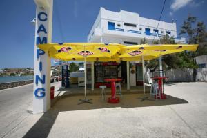 a yellow umbrella in front of a gas station at Camping Koula in Parikia
