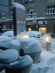 ザグレブにあるホテル クロアチアのホテルの優雅なカフェバーの隣にある雪に覆われた椅子のグループ