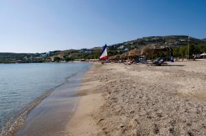 a beach with chairs and umbrellas and the water at Camping Koula in Parikia