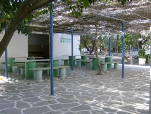 a group of benches and trees in a courtyard at Camping Koula in Parikia