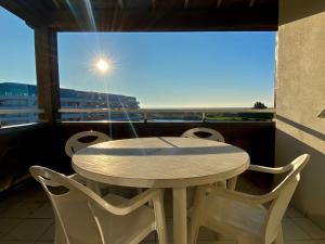 a table and chairs on a balcony with a view at REF 148 Appartement vue mer pour six personnes plage du Fogeo à pieds Port Crouesty ARZON in Arzon +11 photos