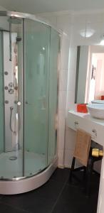 a bathroom with a glass shower and a sink at La Sombra del Viento in La Serena