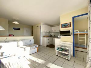 a room with a kitchen with white cabinets and a kitchen at REF 148 Appartement vue mer pour six personnes plage du Fogeo à pieds Port Crouesty ARZON in Arzon