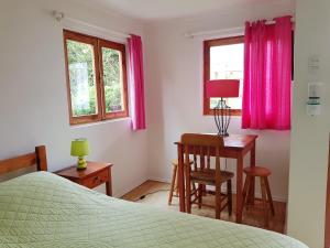 a bedroom with a bed and a table and a desk at La Sombra del Viento in La Serena